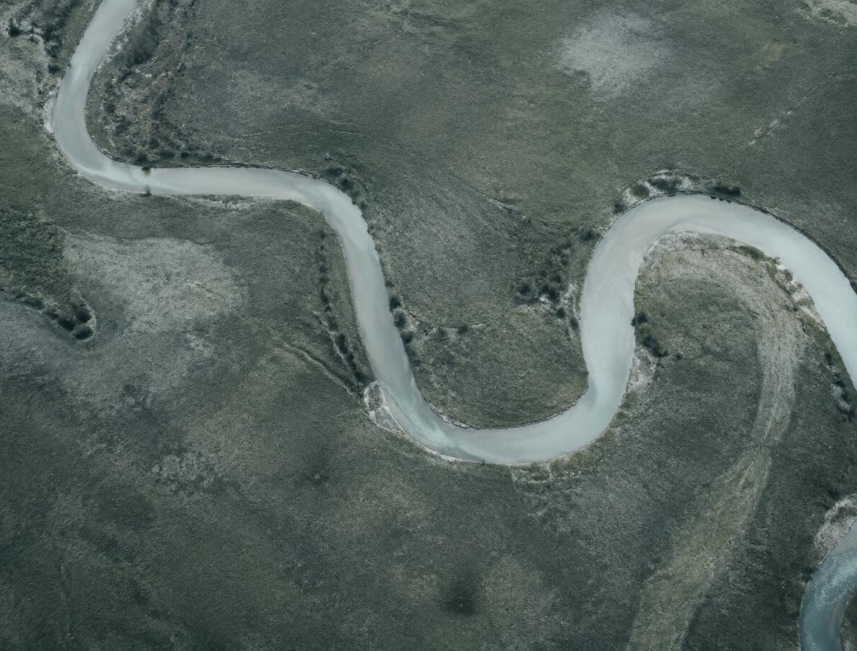 Aerial view of a winding river through a muted landscape